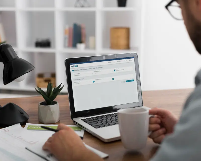 Person using a computer holding a mug